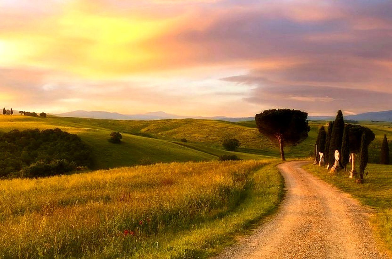 Strada bianca tra le colline al tramonto
